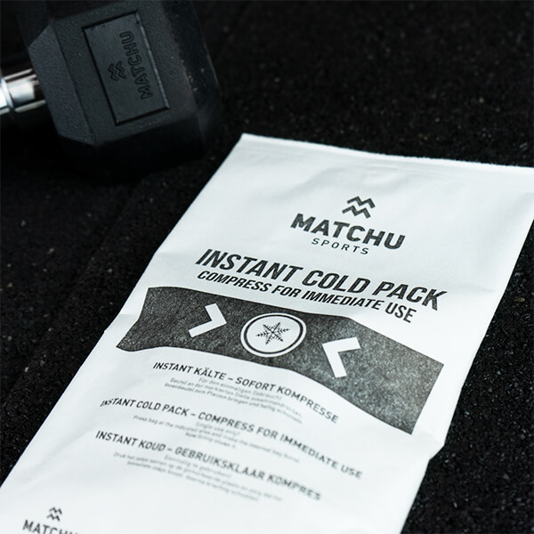 matchu instant cold pack naast dumbbell op sportschoolvloer